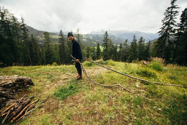 Homem hipster feliz coletar lenha na floresta — Fotografia de Stock