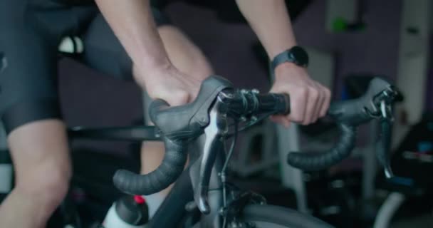 Treinamento de homem adulto em treinador de bicicleta inteligente indoor — Vídeo de Stock