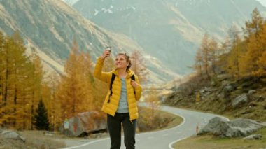 Destansı sonbahar dağlarında yürüyüş yapan bir kadın gezgin.