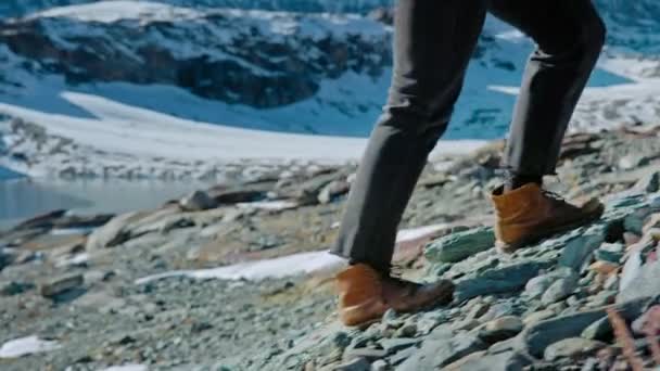 Woman in hard duty leather boots climb rocky hill — Stock Video