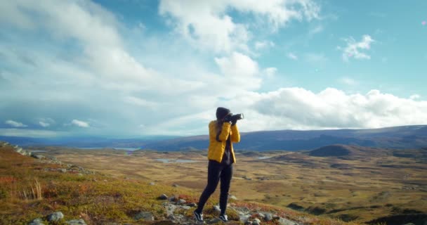 Фотографка знімає пейзаж у горах — стокове відео