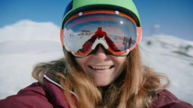 Genç kadın snowboardcu kayak merkezinin asansöründe dönüyor.