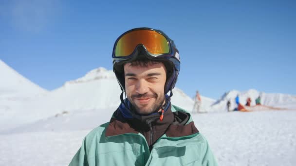 Feliz retrato de esquiador, poner gafas de sol en la pendiente — Vídeos de Stock