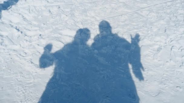 新雪の上に数人のスキーヤーが影に手を振る — ストック動画