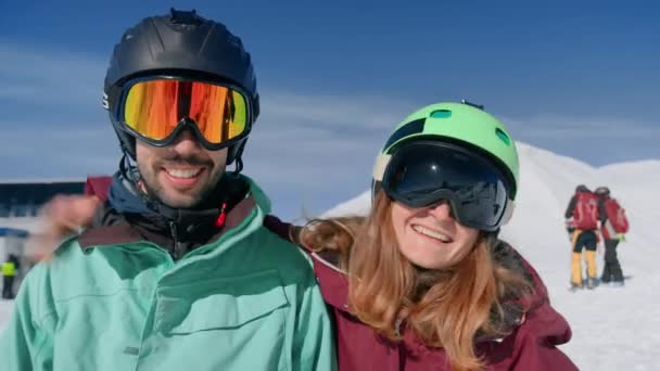 Двоє друзів в лижних окулярах позують посміхаючись для фотографій — стокове відео