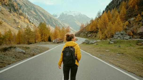 Nő utazó túrázik epikus őszi hegyekben — Stock videók