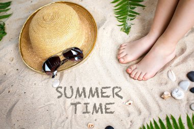 Sandy beach bir şapka, güneş gözlüğü ve çocuk ayak