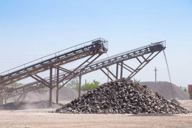 Ezici makineler, koni tipi kaya öğütücü, taş ocağında ezilmiş granit çakıl taşlarını taşıma. Ezilmiş taş ve çakıl işleme tesisi. Madencilik ve Madencilik ekipmanları.