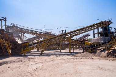 Ezici makineler, koni tipi kaya öğütücü, taş ocağında ezilmiş granit çakıl taşlarını taşıma. Ezilmiş taş ve çakıl işleme tesisi. Madencilik ve Madencilik ekipmanları.