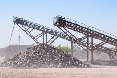 Ezici makineler, koni tipi kaya öğütücü, taş ocağında ezilmiş granit çakıl taşlarını taşıma. Ezilmiş taş ve çakıl işleme tesisi. Madencilik ve Madencilik ekipmanları.
