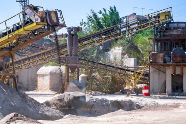 Ezici makineler, koni tipi kaya öğütücü, taş ocağında ezilmiş granit çakıl taşlarını taşıma. Ezilmiş taş ve çakıl işleme tesisi. Madencilik ve Madencilik ekipmanları.