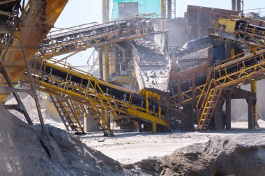 Ezici makineler, koni tipi kaya öğütücü, taş ocağında ezilmiş granit çakıl taşlarını taşıma. Ezilmiş taş ve çakıl işleme tesisi. Madencilik ve Madencilik ekipmanları.