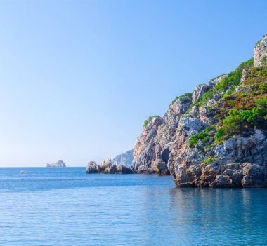 Güzel yaz panoramik deniz manzarası. Güneş ışığında berrak masmavi su ile defne deniz görünüme uçurumdan. Tekneler ve yatlar liman. Akdeniz, Avrupa'da bir yerde.