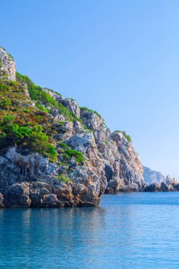 Güzel yaz panoramik deniz manzarası. Güneş ışığında berrak masmavi su ile defne deniz görünüme uçurumdan. Tekneler ve yatlar liman. Akdeniz, Avrupa'da bir yerde.