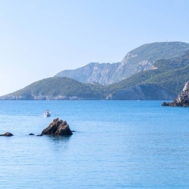Güzel yaz panoramik deniz manzarası. Güneş ışığında berrak masmavi su ile defne deniz görünüme uçurumdan. Tekneler ve yatlar liman. Akdeniz, Avrupa'da bir yerde.