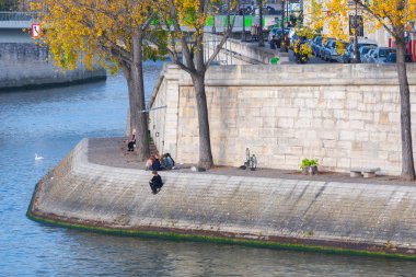 Embankment of the Seine at sunny autumn afternoon. Tourists and natives a walk and relax in warm weather. Blurred unrecognizable faces. Paris. France. clipart