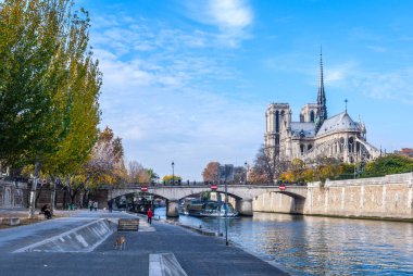 Katedrali Notre Dame de Paris güneşli sonbahar öğleden sonra. Seine Nehri çıkabilir. Yerliler ve turistler bir yürüyüşe ve sıcak havalarda rahatla. Bulanık, tanınmayan yüzler. Paris. Fransa.