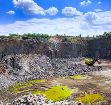Bir büyük Zincirli ekskavatör Granit taş ocağı açık Ocak madenciliği. İşlem üretim taş ve çakıl. Taş ocağı madencilik ekipmanları.
