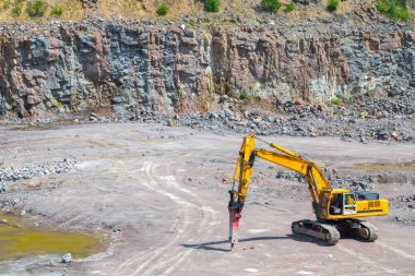 Bir büyük Granit taş ocağı açık Ocak madenciliği çekiçleri Ekskavatör eki izleniyor. İşlem üretim taş ve çakıl. Taş ocağı madencilik ekipmanları.