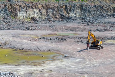Bir büyük Granit taş ocağı açık Ocak madenciliği çekiçleri Ekskavatör eki izleniyor. İşlem üretim taş ve çakıl. Taş ocağı madencilik ekipmanları.