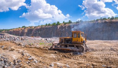 Büyük izlenen buldozer Granit taş ocağı açık Ocak madenciliği içinde. İşlem üretim taş ve çakıl. Taş ocağı madencilik ekipmanları.