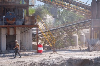 Ezici makineler, koni tipi kaya öğütücü, taş ocağında ezilmiş granit çakıl taşlarını taşıma. Ezilmiş taş ve çakıl işleme tesisi. Madencilik ve Madencilik ekipmanları.