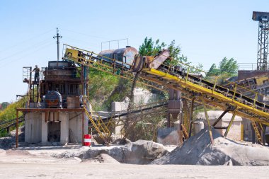 Ezici makineler, koni tipi kaya öğütücü, taş ocağında ezilmiş granit çakıl taşlarını taşıma. Ezilmiş taş ve çakıl işleme tesisi. Madencilik ve Madencilik ekipmanları.
