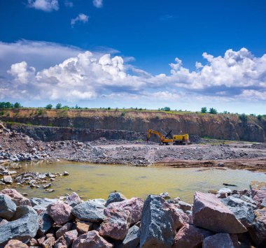 Granit taş ocağı açık Ocak madenciliği muhteşem panoramik manzaralı. İşlem üretim taş ve çakıl. Taş ocağı madencilik ekipmanları. Bir büyük Zincirli ekskavatör ve çekiçleri.