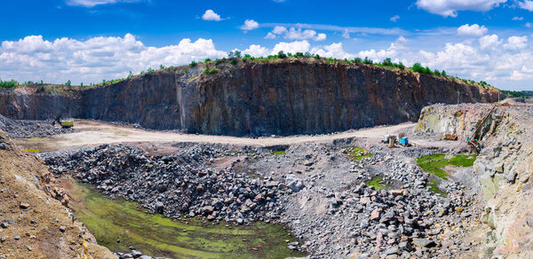 Spectacular panoramic view of quarry open pit mining of granite stone. Process production stone and gravel. Quarry mining equipment.