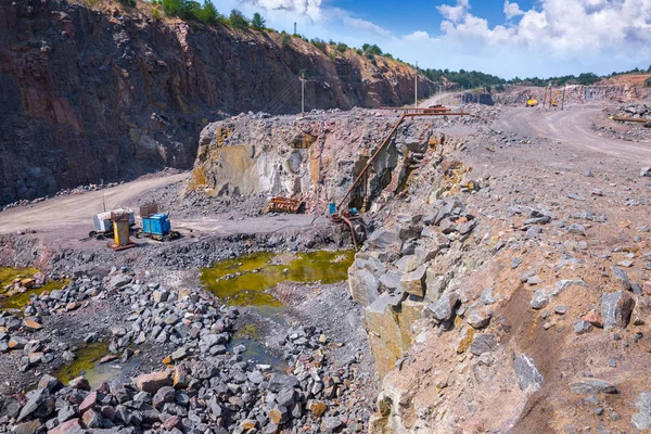 View of quarry open pit mining of granite stone. Process production stone and gravel. Pumping groundwater in the quarry.