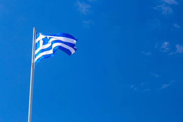 Hellas 'flagg på flaggstangen på en dyp, blå bakmann – stockfoto
