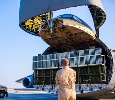 Mühendislerden oluşan bir ekip, Abd Hava Kuvvetleri askerleri bir kargo uçağı hizmet.