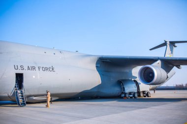 Mühendislerden oluşan bir ekip, Abd Hava Kuvvetleri askerleri bir kargo uçağı hizmet.