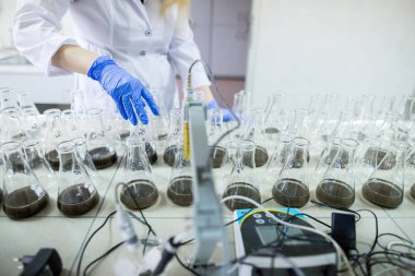 Laboratuvarda bilim adamının elleri d ile bir cam şişe sallamak