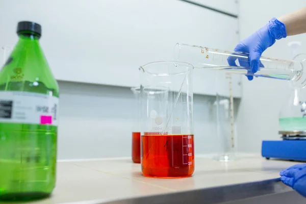 Hands of the scientist in the laboratory mixes with transfusion