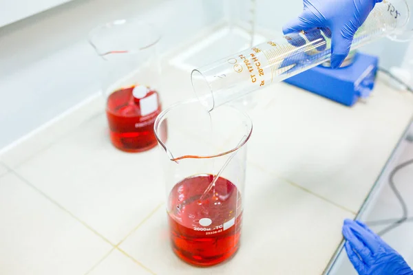 Hands of the scientist in the laboratory mixes with transfusion