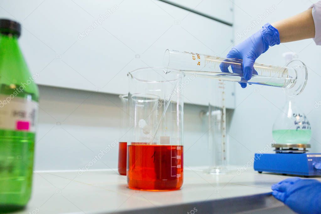 Hands of the scientist in the laboratory mixes with transfusion 