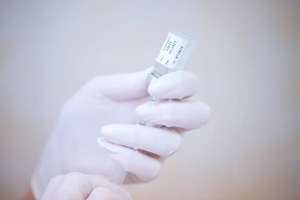 Verpleegkundige hand houden van een injectiespuit en flacon dosis met vaccin of drugs — Stockfoto