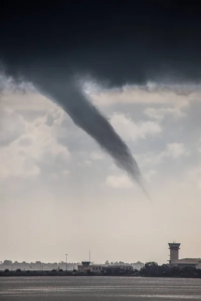 A rope tornado above the runway and airport traffic control towe