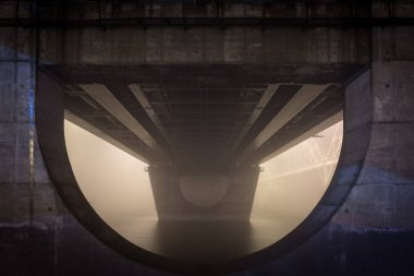 Büyük şehirde nehrin üzerinde gizemli bir akşam sisi. Köprü içinde 