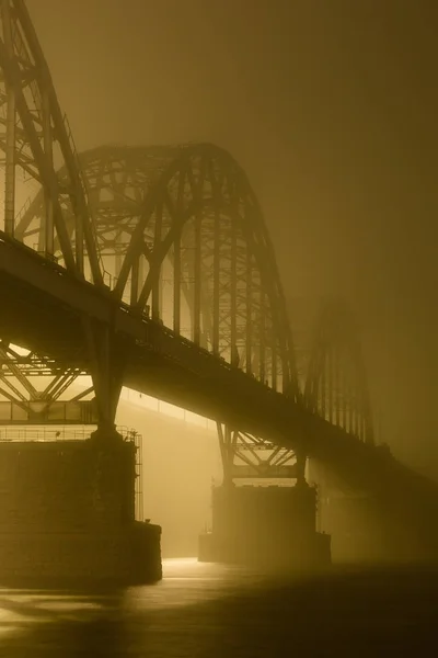 Uma noite misteriosa neblina acima do rio na cidade grande. Ponte em — Fotografia de Stock