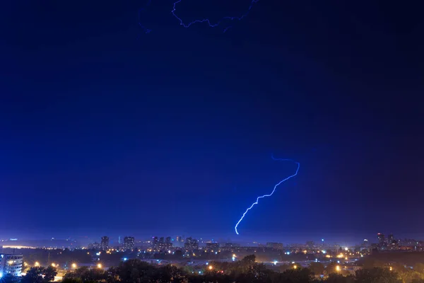 Lightning over the city at the summer storm. Dramatic, breathtak — Stock Photo, Image