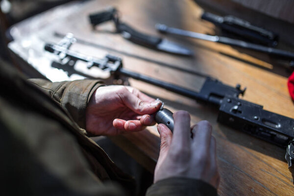 male person soldier cleans the weapon, disassemble, make mainten