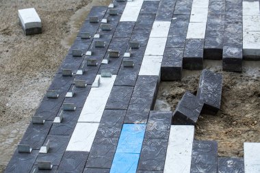 Asfalt inşaatı. Kaldırıma beton kaldırım taşları yerleştirildi. Asfalt sıraları çoktan hazır. Beton harcı toplamak biraz zaman alacaktır..