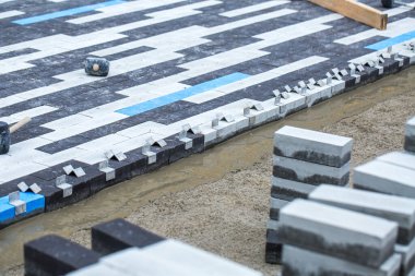 Asfalt inşaatı. Kaldırıma beton kaldırım taşları yerleştirildi. Asfalt sıraları çoktan hazır. Beton harcı toplamak biraz zaman alacaktır..