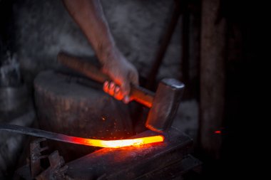 Demircinin elleri iş başında. Bir elinde çekiç, diğer elinde sıcak metalden bir iş parçası. Usta düzenli olarak örse vuruyor. Eski el sanatlarının sıkı çalışmasına bir örnek..