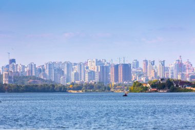 Yaz güneşli sıcak bir akşam. Modern yerleşim bölgeleri güney banliyöleri ve şehir merkezleri Kyiv 'de, Dnipro Nehri' nin sağ kıyısında. Ön planda teknelerde balıkçılar. Kyiv. Ukrayna. 28 Ağustos 2019