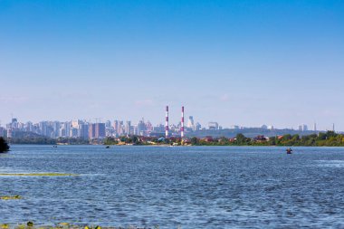 Yaz güneşli sıcak bir akşam. Modern yerleşim bölgeleri güney banliyöleri ve şehir merkezleri Kyiv 'de, Dnipro Nehri' nin sağ kıyısında. Ön planda teknelerde balıkçılar. Kyiv. Ukrayna. 28 Ağustos 2019