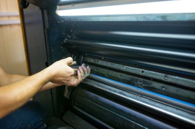 Ustanın servisi endüstriyel baskı makinesi. Yazdırma şaftlarını ayarlama ve kalıp kalıplarını düzeltme süreci.