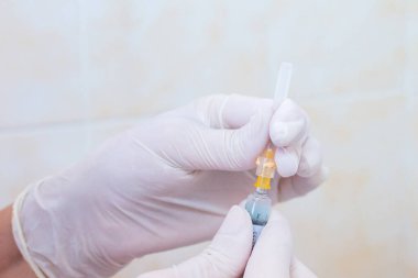 Hemşire elinde aşı ya da ilaçla şırınga ile enjeksiyona hazırlanıyor. Tıbbi konsept: Aşı, iğne, tedavi, hastalık, hastane, aşı, hastalık,.